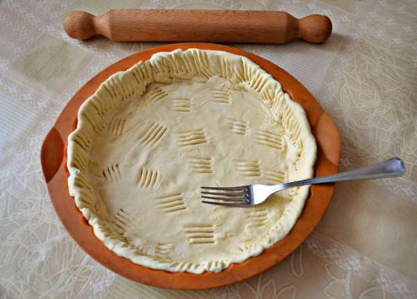 В форму смазанную маслом (если силиконовая, как у меня, то не нужно, можно лишь сбрызнуть её холодной водой) выложить тесто, сформировать небольшие бортики и наколоть вилкой. Отправить в разогретую до 200°C духовку на 10-15 минут.