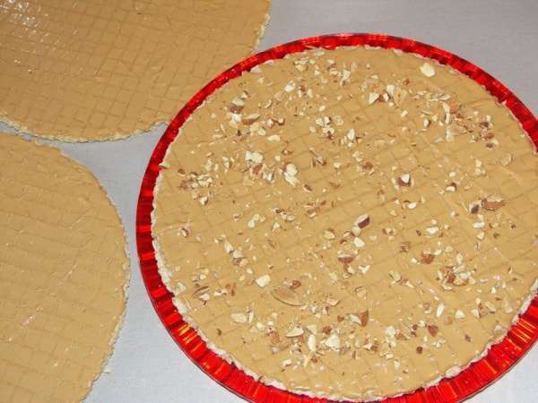 Нижний смазываем, посыпаем орехами и накрываем вторым смазанной стороной вниз.