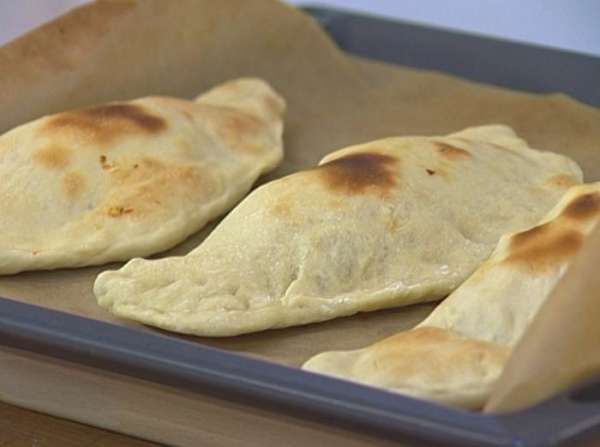 Уложить пиццы на противень, застеленный бумагой для выпечки, смазать оливковым маслом и выпекать в разогретой духовке 15‒20 минут.