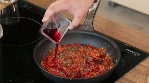 Сразу же добавить ложечку сахара, специи по вкусу (сушеные орегано, базилик) соль и перец. По желанию можно влить 50 мл вина. Перемешать, накрыть сковороду крышкой и потушить соус на медленном огне 20 — 25 минут.
