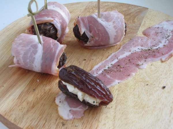Полоски бекона поперчить по вкусу и завернуть в них финики. Сколоть шпажкой или зубочисткой. Полоски бекона поперчить по вкусу и завернуть в них финики. Сколоть шпажкой или зубочисткой.