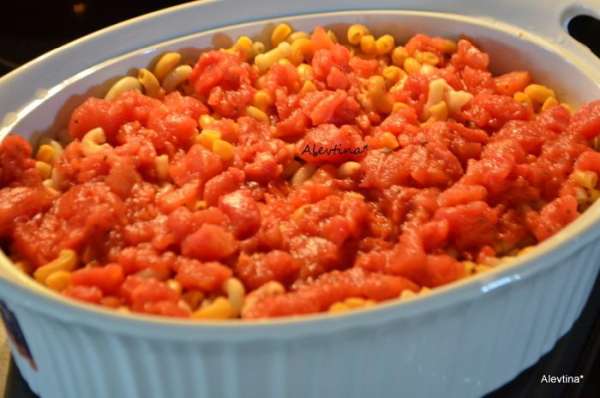 Переложить макароны и кусочки курицы в блюдо для запекания, перемешать. Добавить сверху консервированные томаты в соку, порезанные кубиками.