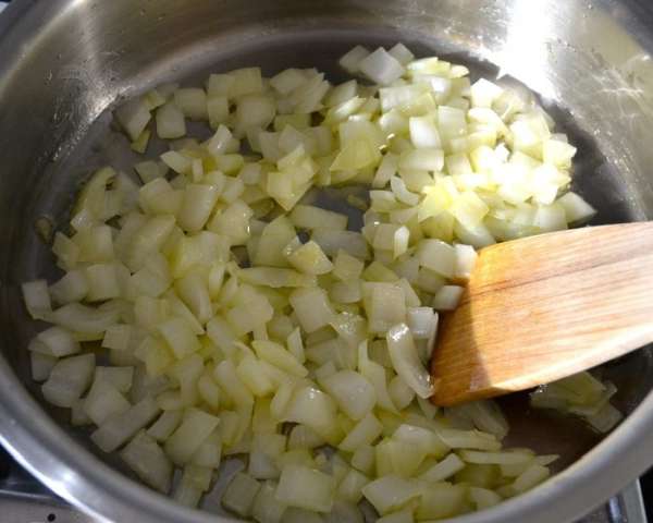 Когда мясо будет готово, займемся приготовлением соуса. Для этого лук нарезать небольшими кубиками. В сковороде разогреть масло и обжарить лук до прозрачности. 