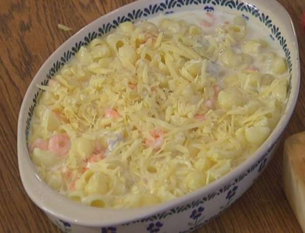 Макароны в форме залить горячим молоком и посыпать оставшимся сыром.