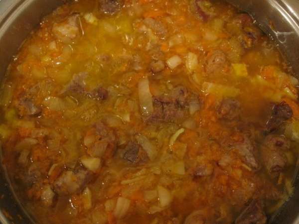 Добавить вино, постоянно помешивая.
Бросить мясо в сковороду и жарить, пока объём вина не уменьшится вдвое. Залить 300-400 мл куриного бульона и рубленые свежие травы. Посолить, поперчить. Сделать огонь на минимум и тушить под крышкой 1,5 часа, периодически помешивая. Затем снять крышку и готовить ещё около 20-30 минут. При необходимости можно добавлять ещё бульон. 