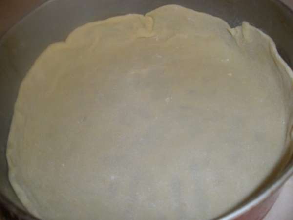 Форму для пирога смазать маслом (у меня 24 см разъемная). Раскатать самый большой кусочек и переложить его в форму. Сделать бортики примерно 3-4 см. Смазать как следует 1/3 части растопленного масла.