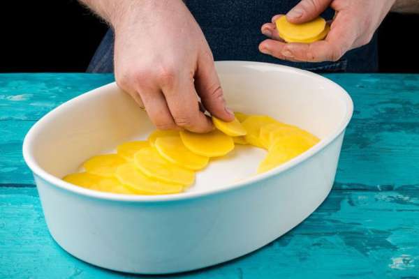 Картофель нарезать кружочками. Форму для запекания смазать оливковым маслом, выложить слой картофеля. Картофель нарезать кружочками. Форму для запекания смазать оливковым маслом, выложить слой картофеля.