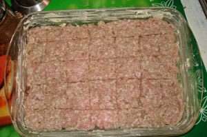 К мясному фаршу добавить луковую смесь. Все перемешать. Противень смазать маслом и выложить фарш слоем 1-2 см. Сверху тупой стороной ножа прочертить решетку, чтобы предохранить от растрескивания.