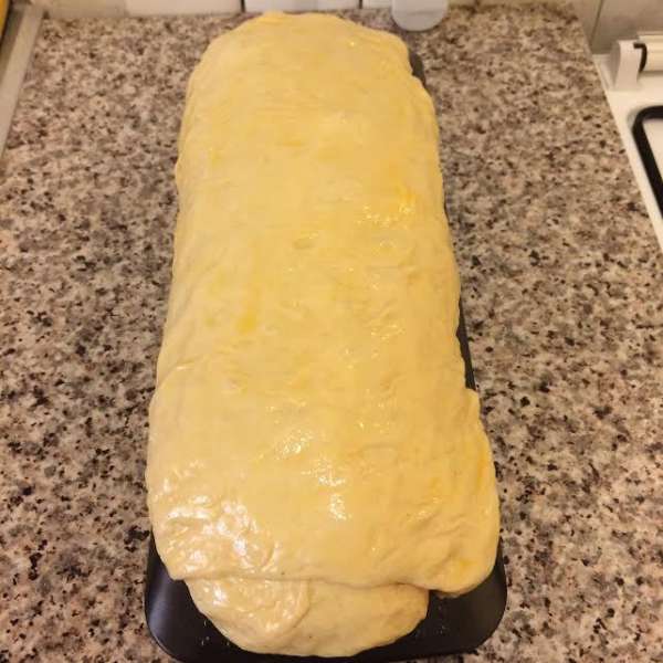 Духовку нагреть до 180°С. Желток смешать с молоком и смазать тесто.