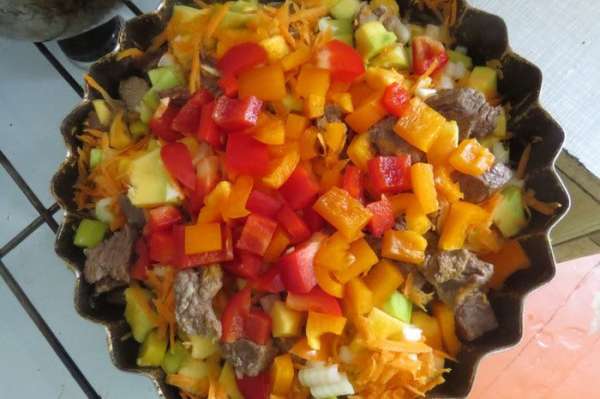 Нарезать мясо небольшими кусочками выложить на сковороду и дать немного поджариться. В это время выложить к мясу тыкву, лук, морковь, перец и соль.