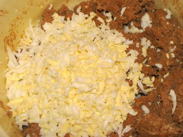 Перемешать получившийся мясной фарш и измельченную печень. Отварные яйца потереть на терке. Добавить сливки.