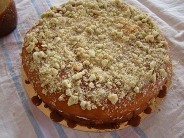 Накрываем вторых коржом, поливаем карамелью, посыпаем орешками и крошкой ореховых безе
