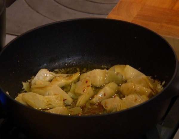 Сухой перец раскрошить и посыпать лук с артишоками.
