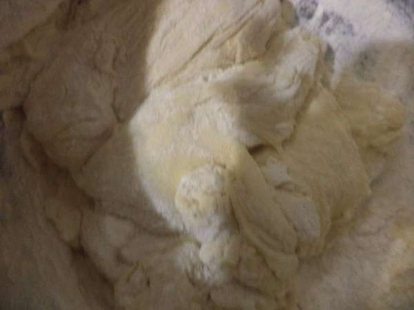 Подмешать к опаре муку, яйцо, растопленное и остывшее сливочное масло, сахар и 1 стакан тёплого молока. Накрыть полотенцем, оставить на 1 час в тёплом месте.