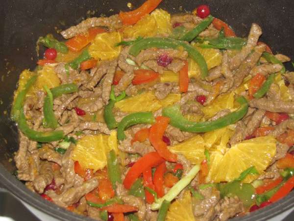 Затем вернуть в сковороду овощи и мясо, добавить нарезанный апельсин. Посолить, поперчить по вкусу и готовить, постоянно, помешивая 2 минуты.