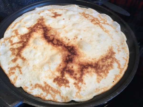 Разогрейте сковороду для блинов и выпекайте тонкие блинчики на среднем огне.
