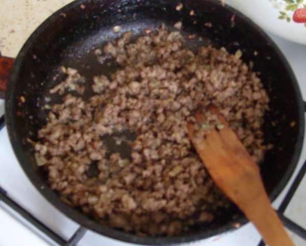 Для начинки лук репчатый мелко порезать и обжарить на оливковом и сливочном масле до золотистого цвета. Затем добавить мясной фарш, слегка обжарить. Тушить до полного выкипания жидкости, посолить, поперчить. По желанию можно влить томатную пасту или просто посыпать базиликом, продолжать тушить еще 3-5 мин.